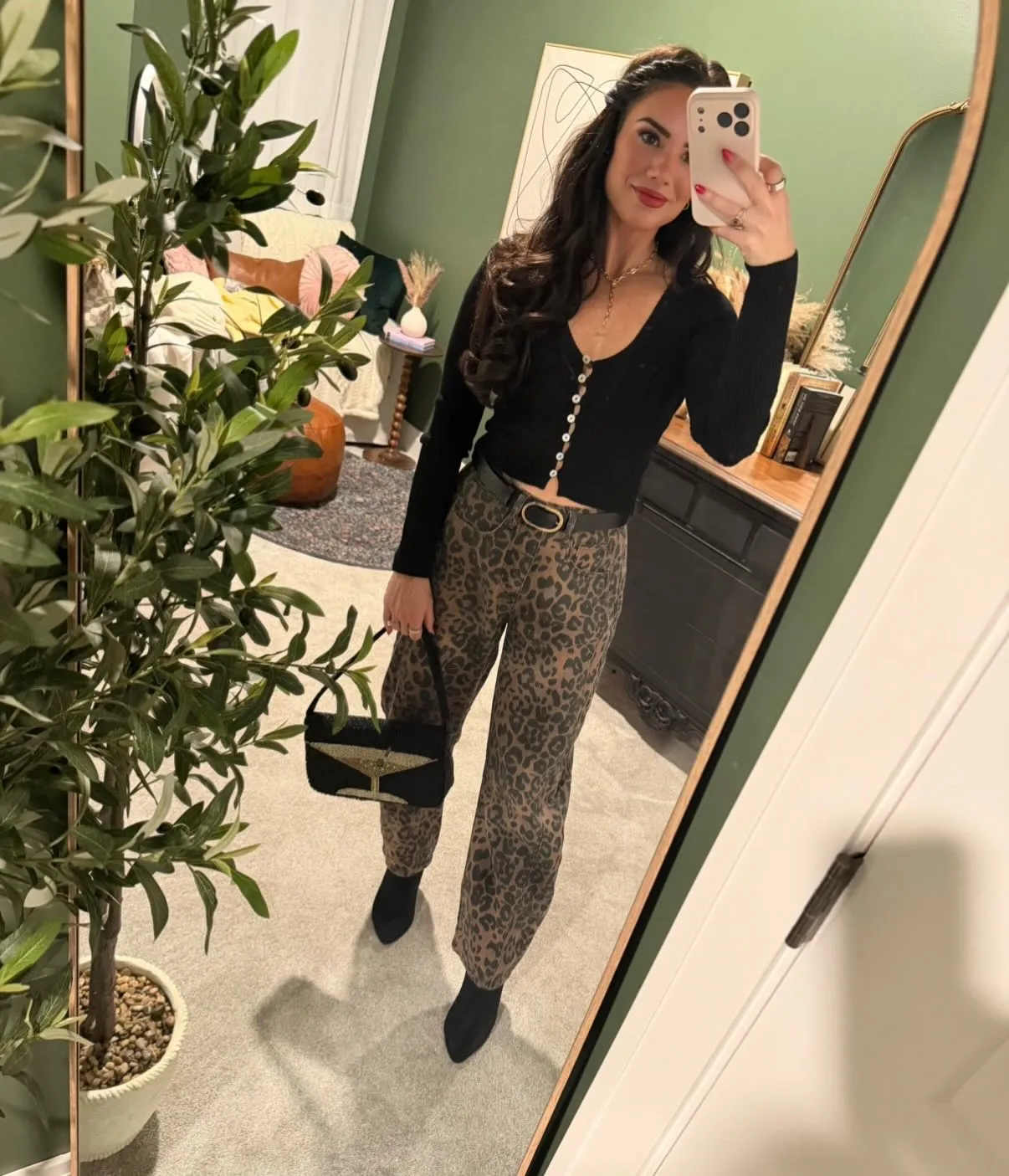 Susanne in a black cropped cardigan and leopard-print barrel jeans with a black belt, beaded martini-glass bag and black boots