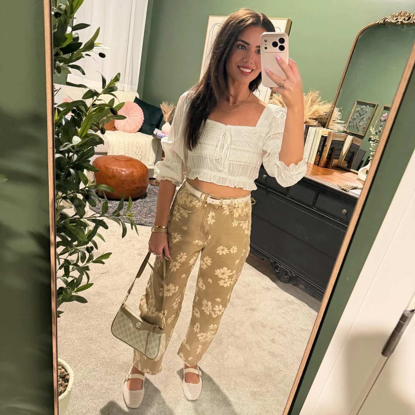 Susanne in a white lace-trimmed crop top and tan floral barrel jeans with a white belt, sage shoulder bag and white mesh Mary Jane flats