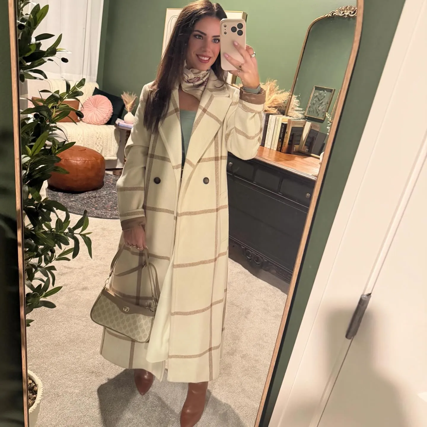 Susanne in a cream windowpane-check wool coat over her sage top and cream skirt, silk scarf at the neck and cognac boots