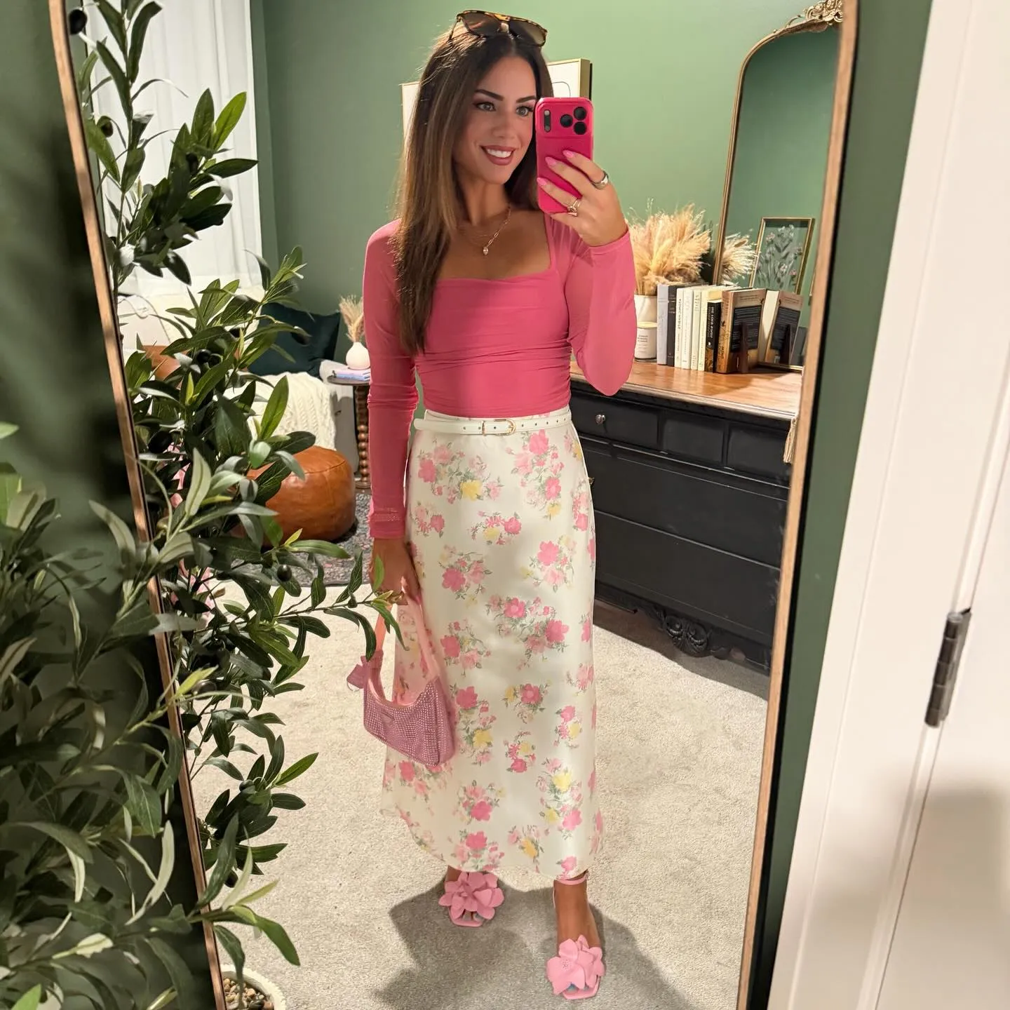 Mirror selfie in a pink long-sleeve mesh bodysuit with a cream floral satin maxi skirt, white belt, pink flower heels and a pink beaded bag.