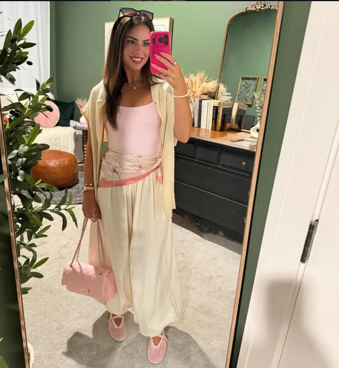 Susanne in a soft blush and cream outfit, photographed in her signature gold arched mirror.